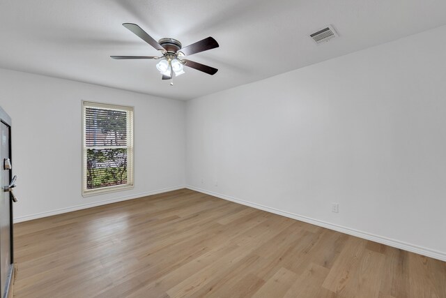 empty room with ceiling fan, visible vents, baseboards, and light wood-type flooring