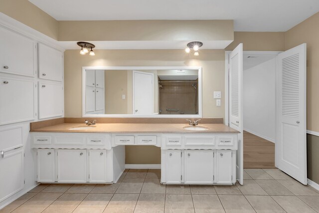 full bathroom with double vanity, tile patterned floors, a sink, and a shower