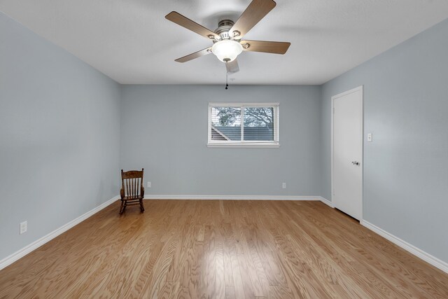 empty room with baseboards, a ceiling fan, and wood finished floors