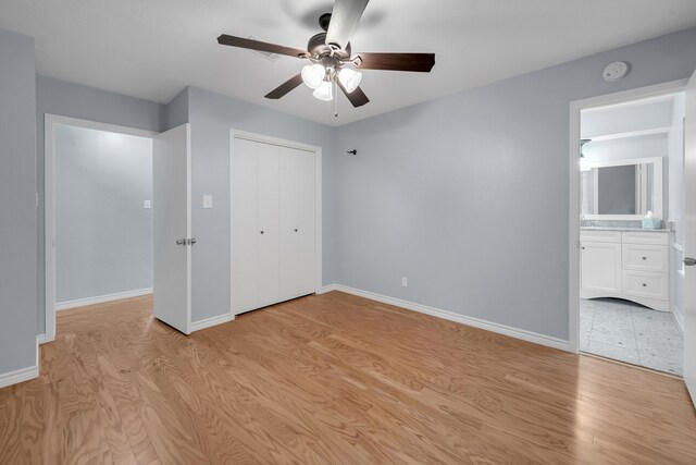 unfurnished bedroom with ceiling fan, baseboards, a closet, light wood-style floors, and ensuite bathroom