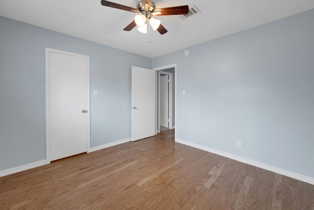 unfurnished bedroom featuring baseboards, visible vents, ceiling fan, and light wood finished floors