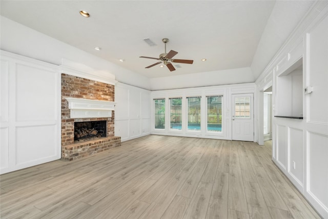 unfurnished living room featuring ceiling fan, visible vents, light wood-style floors, and a decorative wall