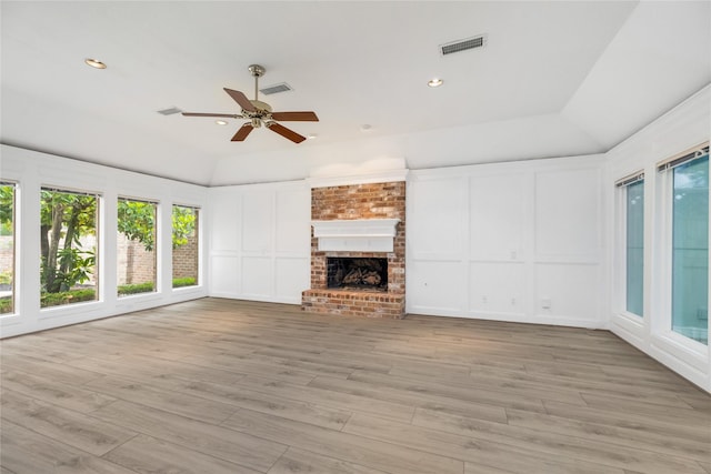 unfurnished living room featuring visible vents, plenty of natural light, and a decorative wall