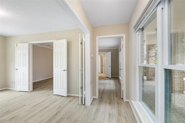 hallway featuring baseboards and light wood-type flooring