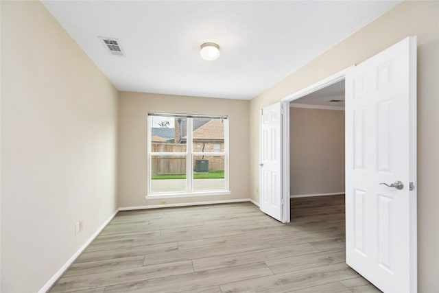 unfurnished room with baseboards, visible vents, and light wood-style flooring