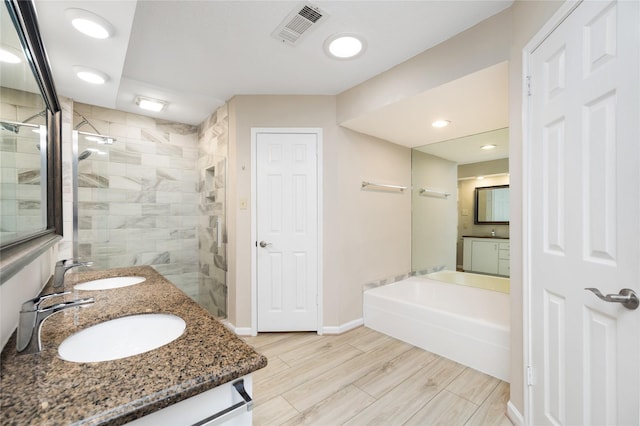 bathroom featuring visible vents, a sink, double vanity, and a shower stall