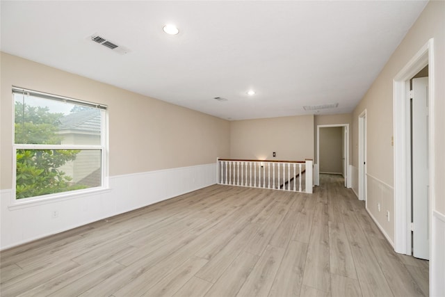empty room featuring recessed lighting, plenty of natural light, light wood finished floors, and visible vents