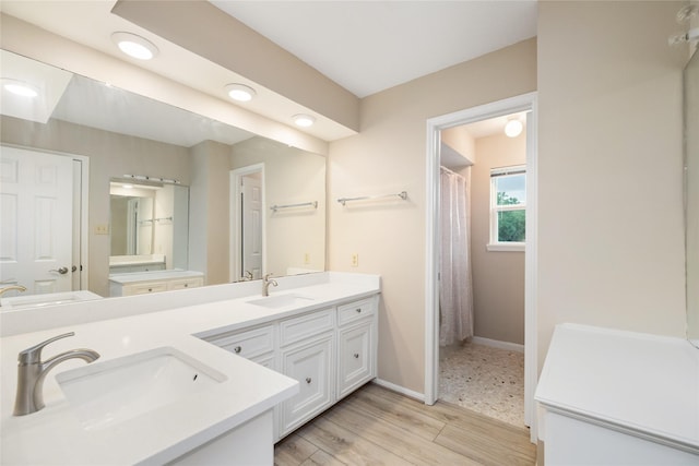 bathroom with baseboards, a sink, and double vanity