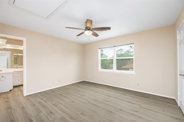 unfurnished bedroom with light wood-style floors, baseboards, ensuite bathroom, and a ceiling fan