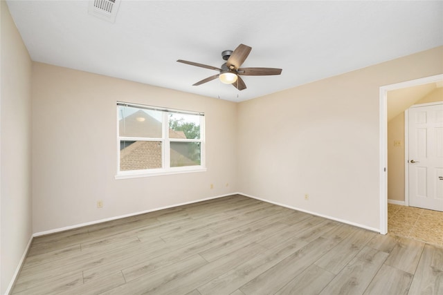 empty room with baseboards, a ceiling fan, light wood finished floors, and visible vents
