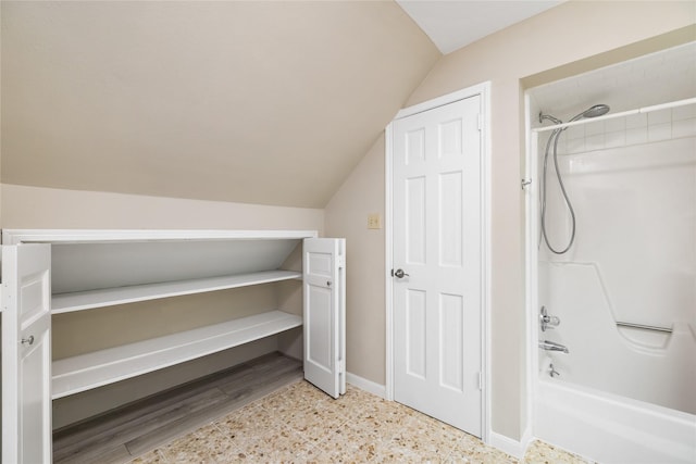 full bathroom with baseboards, vaulted ceiling, and tub / shower combination