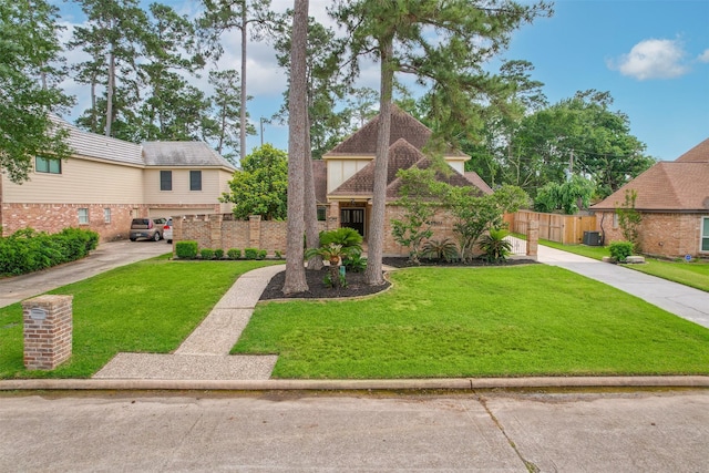 view of front of home with fence, brick siding, and a front yard