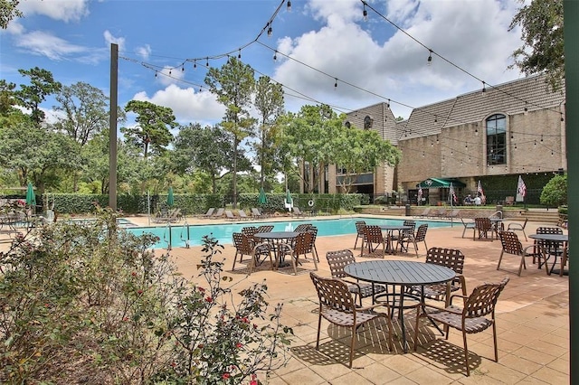 community pool with fence and a patio area