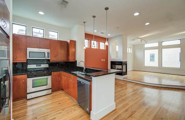 402 Parker St, Houston, TX 77007 - kitchen with a sink, stainless steel appliances, open floor plan, a peninsula, and visible vents