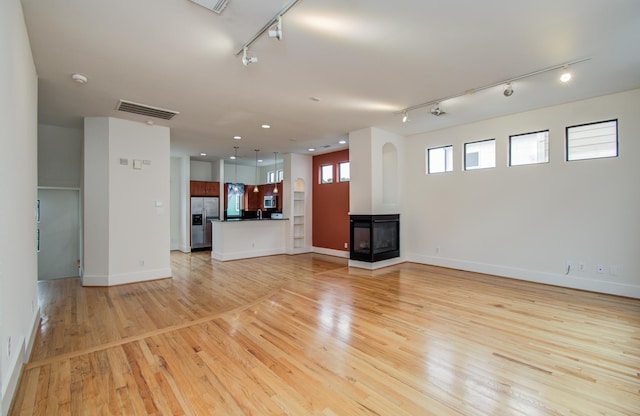 402 Parker St, Houston, TX 77007 - unfurnished living room featuring track lighting, light wood finished floors, recessed lighting, baseboards, and visible vents