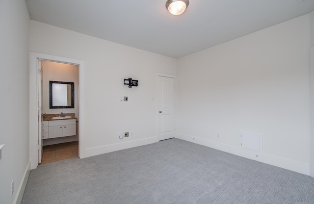 402 Parker St, Houston, TX 77007 - unfurnished bedroom with light colored carpet, a sink, baseboards, and ensuite bath