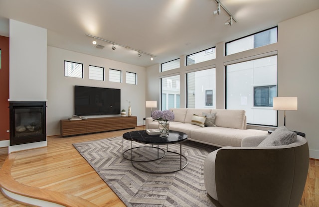 402 Parker St, Houston, TX 77007 - living room featuring track lighting, a glass covered fireplace, wood finished floors, and visible vents