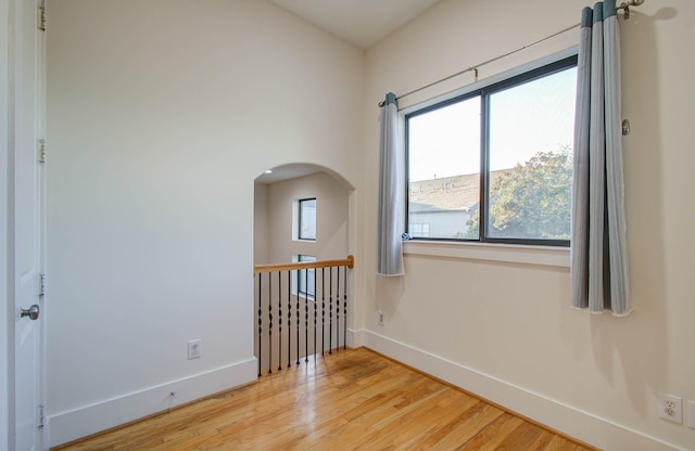 402 Parker St, Houston, TX 77007 - unfurnished room featuring arched walkways, baseboards, light wood-type flooring, and a wealth of natural light