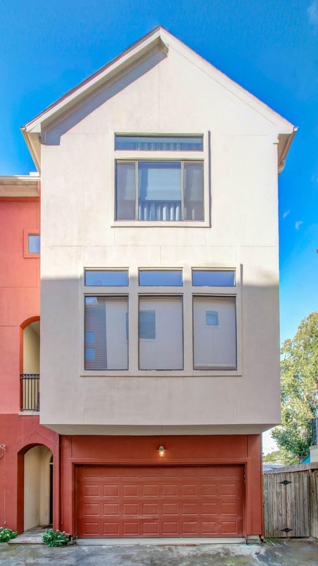 402 Parker St, Houston, TX 77007 - view of front facade featuring an attached garage, fence, and stucco siding