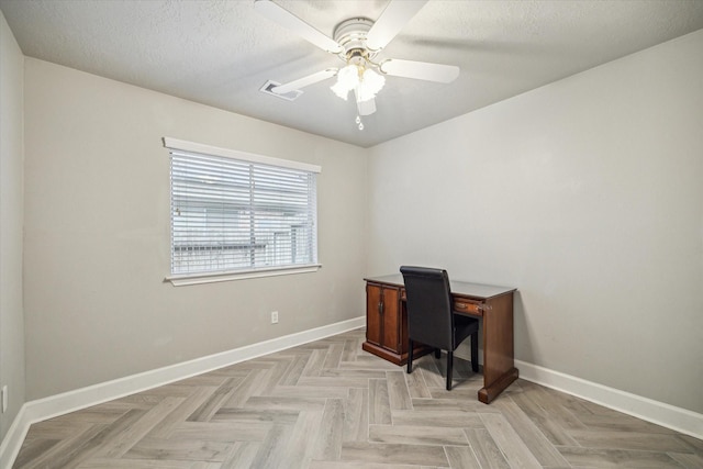 unfurnished office featuring baseboards, ceiling fan, a textured ceiling, and visible vents