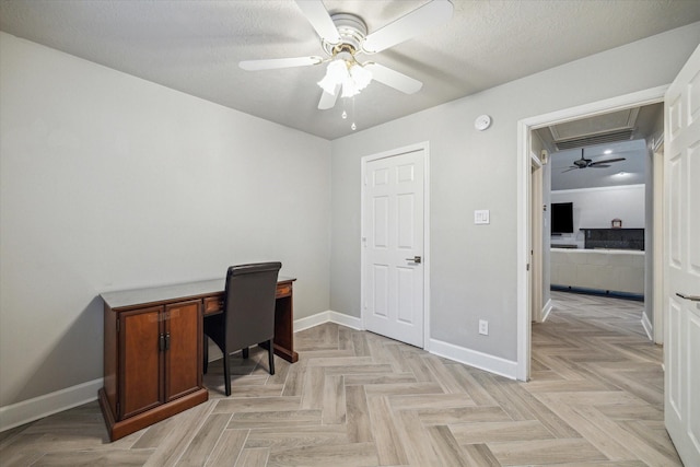home office with baseboards, a ceiling fan, and attic access