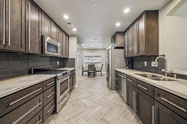 kitchen featuring a sink, visible vents, stainless steel appliances, and dark brown cabinets