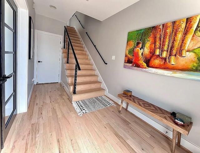 stairway featuring baseboards and wood finished floors