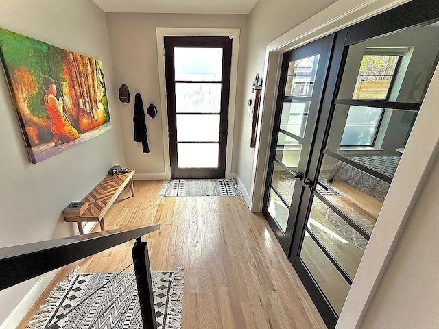 entryway with french doors, baseboards, and wood finished floors