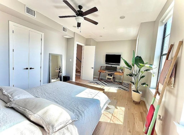 bedroom with baseboards, ceiling fan, light wood-type flooring, and visible vents