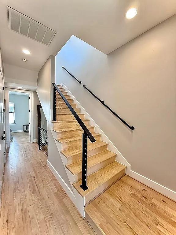 stairway featuring visible vents, recessed lighting, baseboards, and wood finished floors