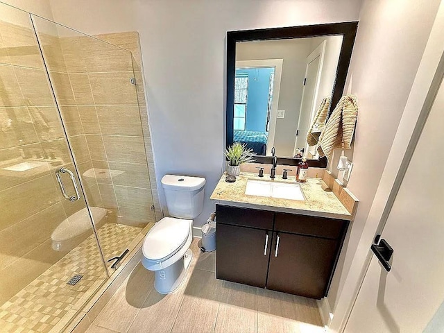 full bath featuring vanity, toilet, baseboards, a shower stall, and ensuite bathroom