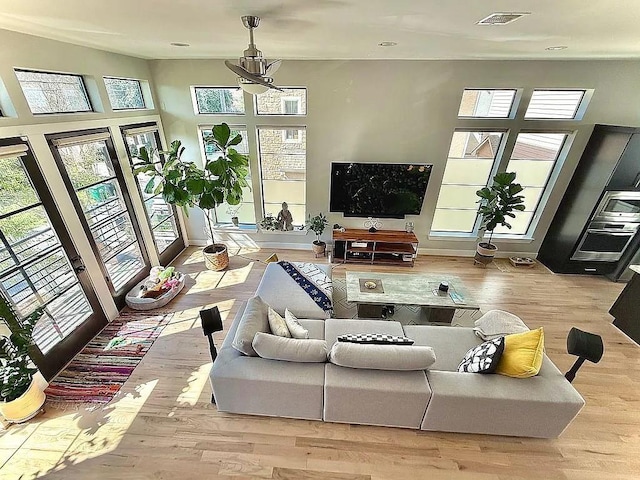 living area featuring a chandelier, french doors, visible vents, and wood finished floors