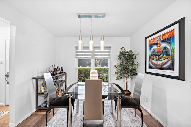 dining area with baseboards and wood finished floors