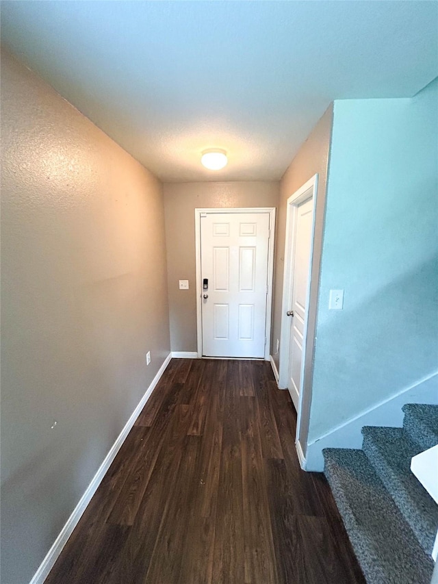 entryway featuring baseboards, stairs, and wood finished floors