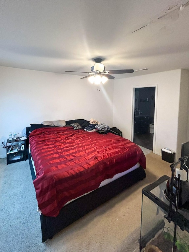 bedroom with carpet floors, ensuite bathroom, and a ceiling fan