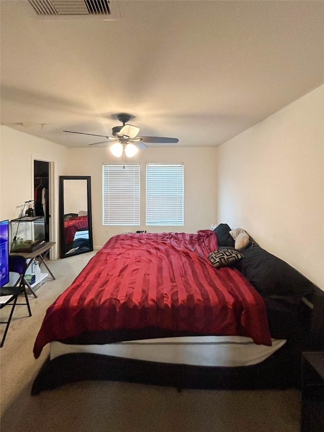 carpeted bedroom with visible vents and ceiling fan