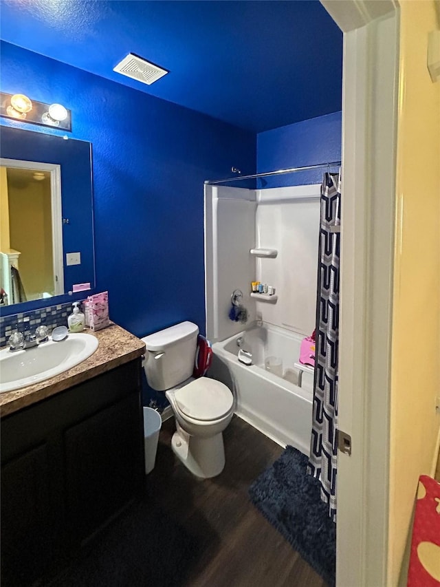 full bath featuring vanity, toilet, wood finished floors, shower / tub combo, and visible vents