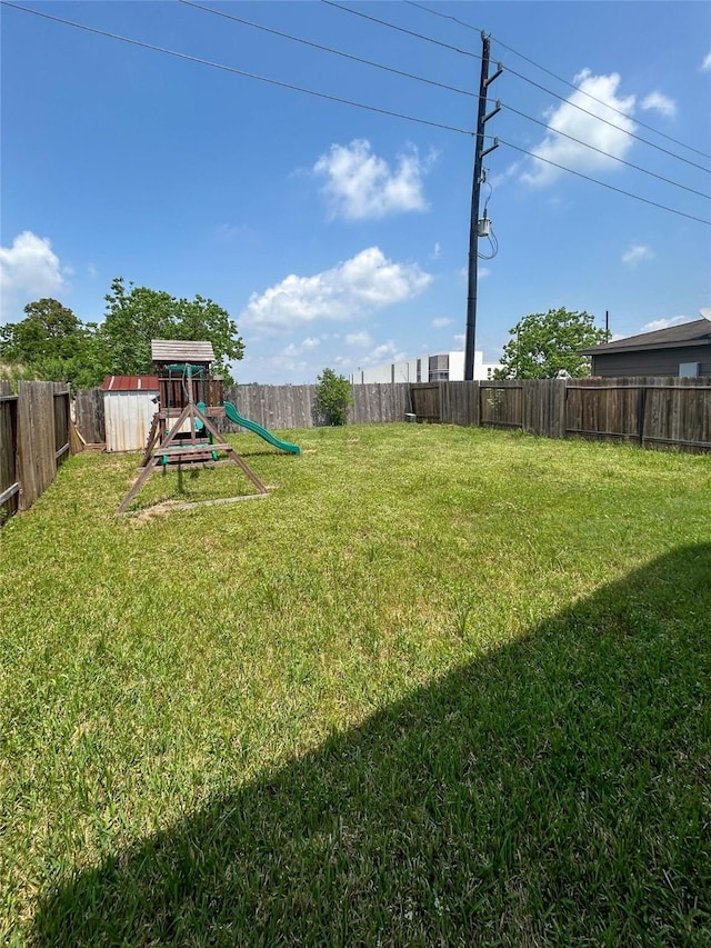view of yard featuring a fenced backyard and a playground