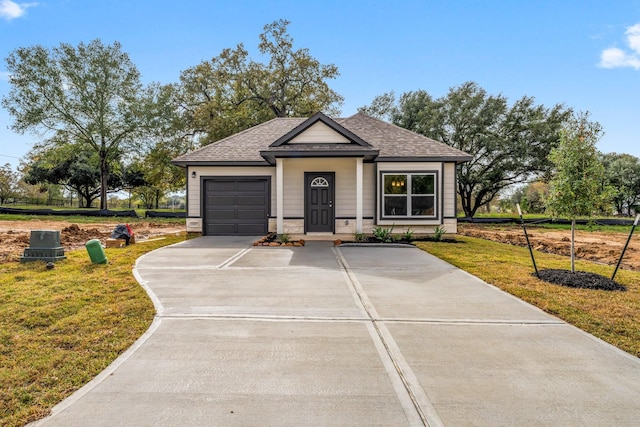 11885 E Gate Dr, Willis, TX 77318 - view of front of home featuring an attached garage, roof with shingles, a front yard, and concrete driveway