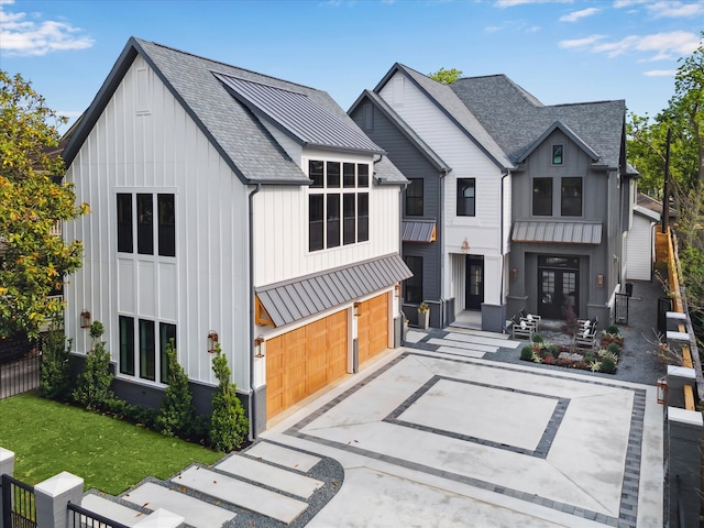 view of front of home featuring board and batten siding, a standing seam roof, metal roof, roof with shingles, and fence