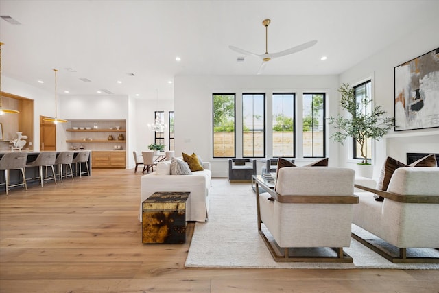 living area with visible vents, recessed lighting, light wood finished floors, and a healthy amount of sunlight