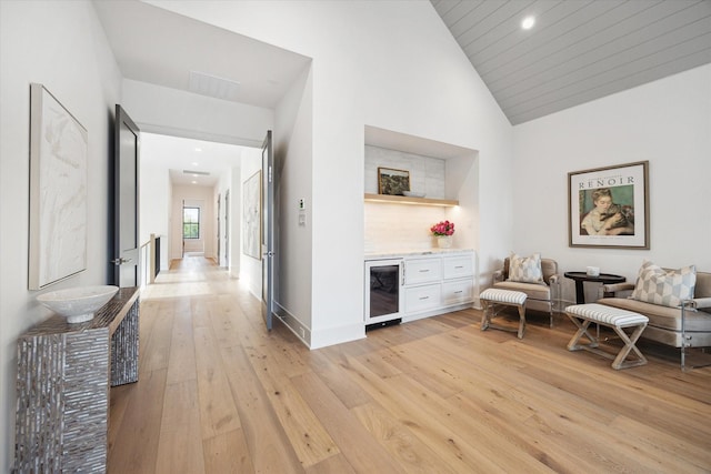 702 E 19th St, Houston, TX 77008 - sitting room with wine cooler, light wood-type flooring, a bar, recessed lighting, and high vaulted ceiling