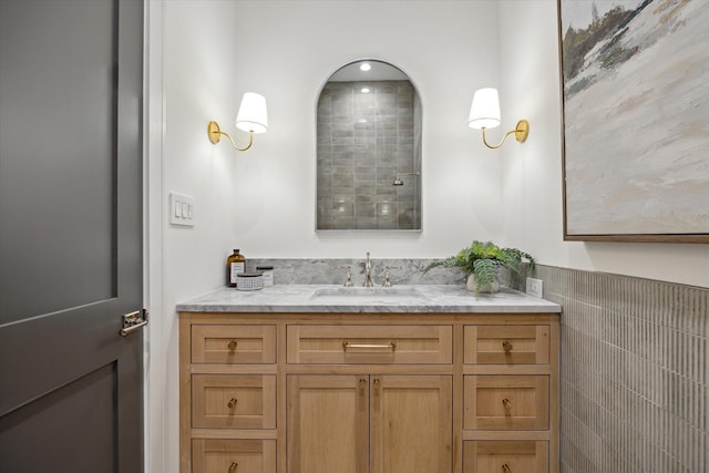 bathroom featuring vanity and tile walls