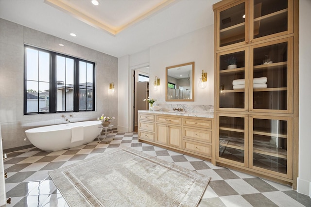 bathroom with vanity, a soaking tub, and recessed lighting