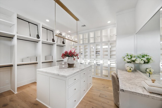 kitchen featuring open shelves, light wood finished floors, white cabinets, and light stone countertops