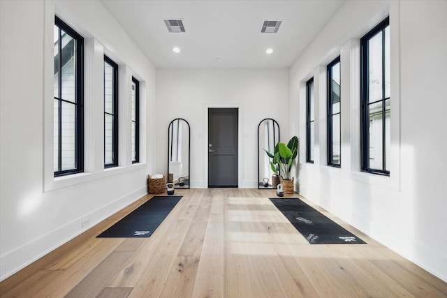 exercise area with visible vents, baseboards, and wood finished floors