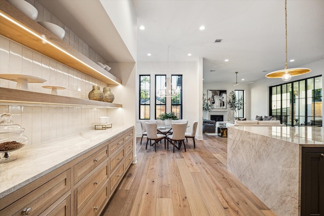 702 E 19th St, Houston, TX 77008 - kitchen with open shelves, light wood-style flooring, recessed lighting, decorative backsplash, and light stone counters