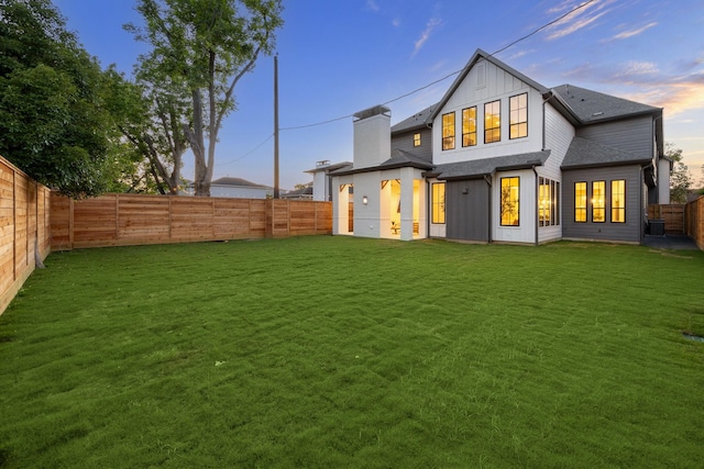 702 E 19th St, Houston, TX 77008 - back of house at dusk featuring board and batten siding and a chimney
