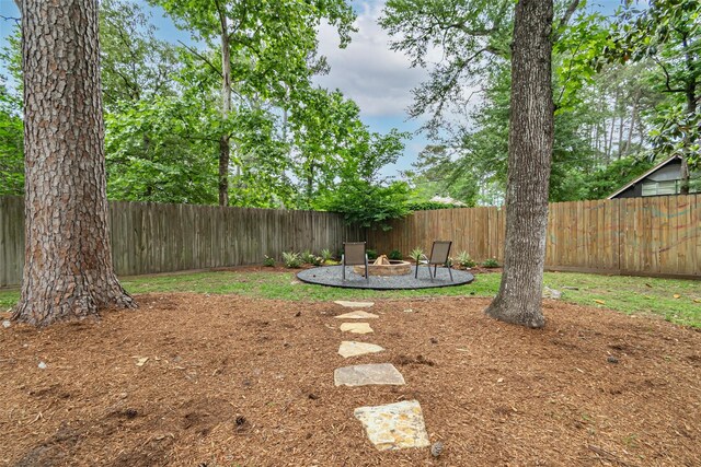 view of yard with a fenced backyard and an outdoor fire pit