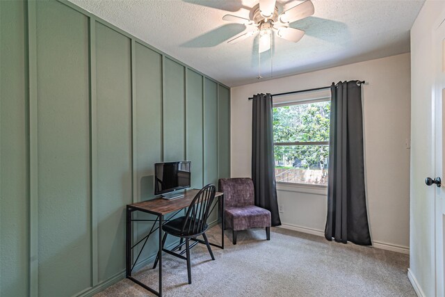 office with baseboards, a ceiling fan, a textured ceiling, and light colored carpet